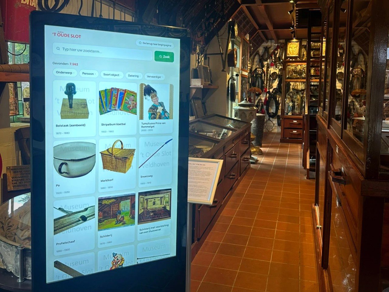 Bezoeker doorzoekt de collectie op een touchscreen zuil in de museumzaal